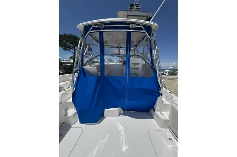 Slide: The Image of 2005 Pro-Line 32 Express boat with blue canopy and clear windows, docked under clear skies. - 12