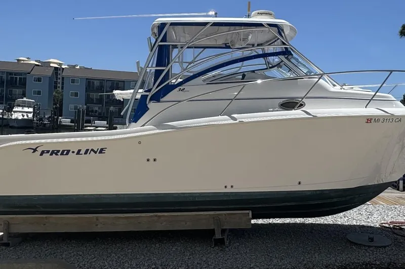 Slide: The Image of 2005 Pro-Line 32 Express boat with twin Suzuki 300 outboard engines, docked on a sunny day. - 2