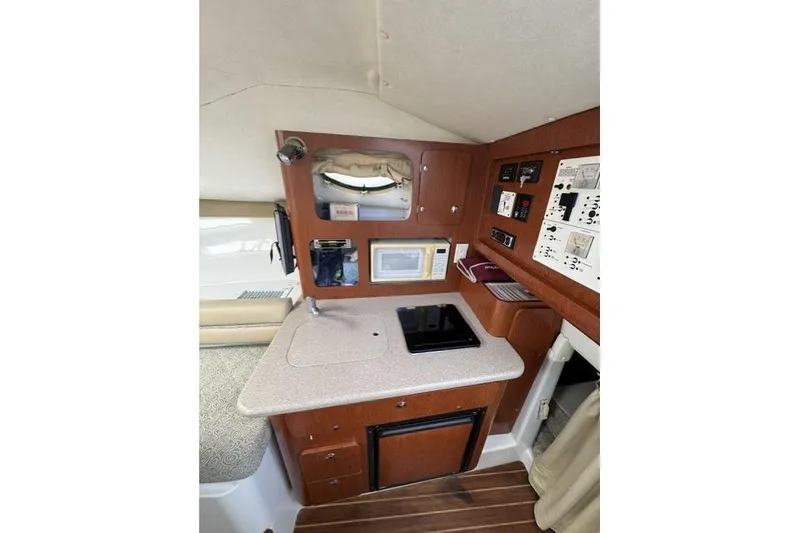Slide: The Image of 2005 Pro-Line 32 Express cabin interior with kitchenette, featuring stove, microwave, and control panels. - 23