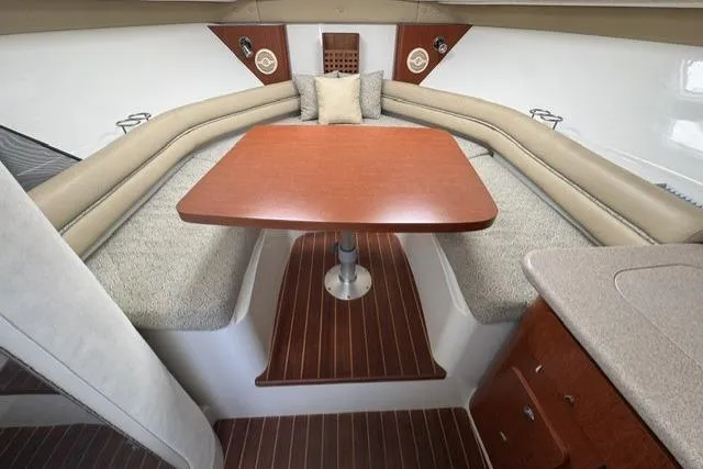 Slide: The Image of Interior of 2005 Pro-Line 32 Express boat with wood table and cushioned seating. - 24