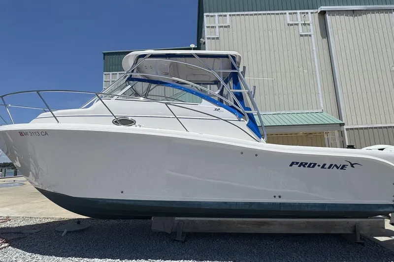 Slide: The Image of 2005 Pro-Line 32 Express boat docked, showcasing sleek design and white exterior. - 5
