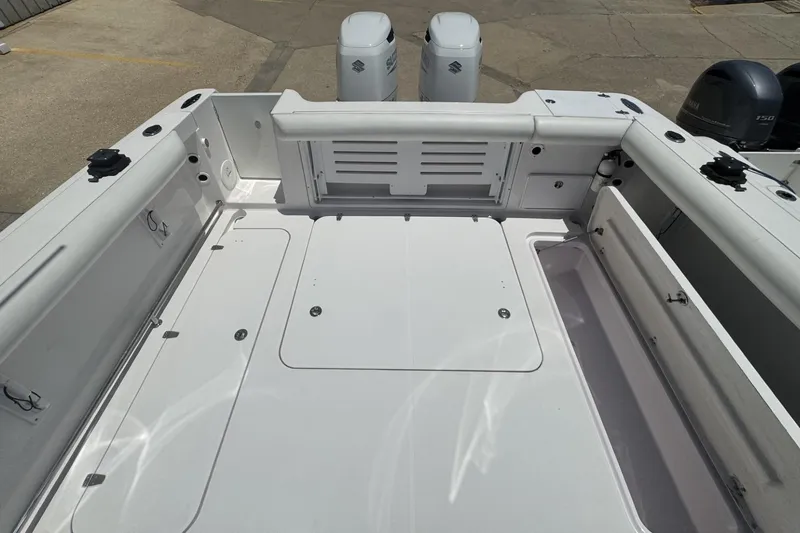 Slide: The Image of 2005 Pro-Line 32 Express boat deck with storage compartments and twin Suzuki outboard engines. - 8