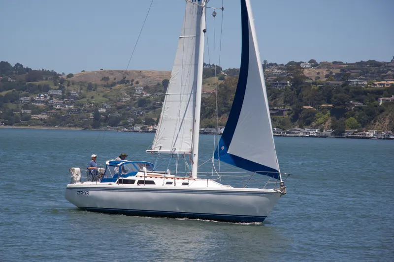 Slide: The Image of Sailboat Catalina 36, 1991 model, cruising on a scenic lake with hills in the background. - 0