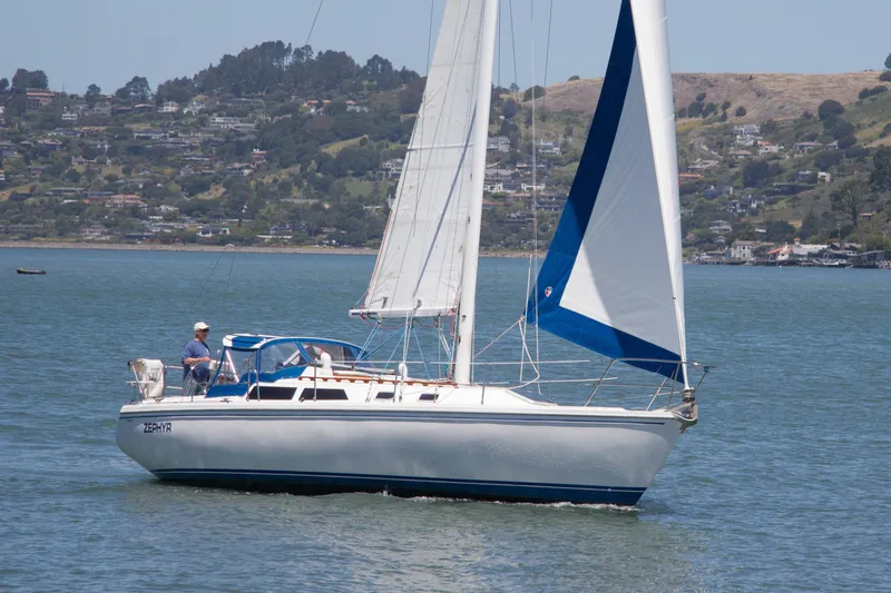 The Image of Sailboat Catalina 36 (1991) cruising on a scenic lake with hills in the background. - 1