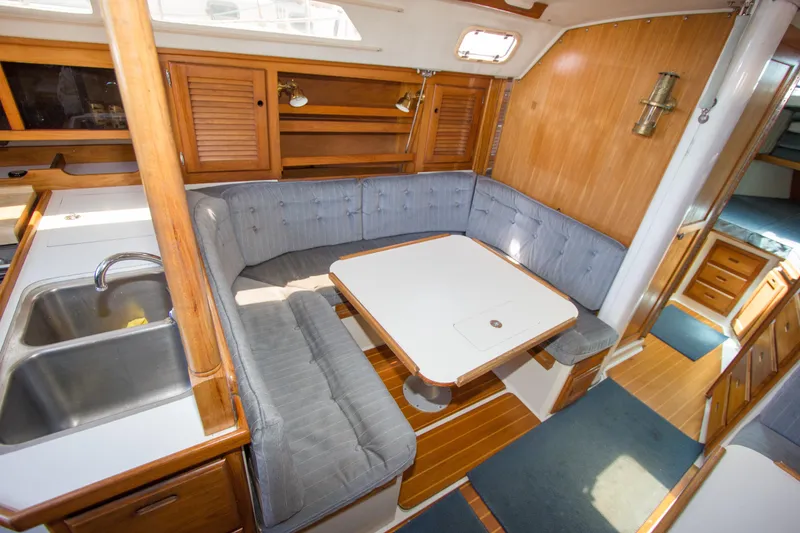 Slide: The Image of Interior of a 1991 Catalina 36 sailboat with cozy dining area and wooden cabinetry. - 10