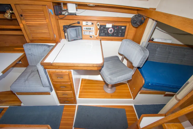 Slide: The Image of 1991 Catalina 36 yacht interior with navigation station, wooden cabinetry, and cushioned seating. - 12
