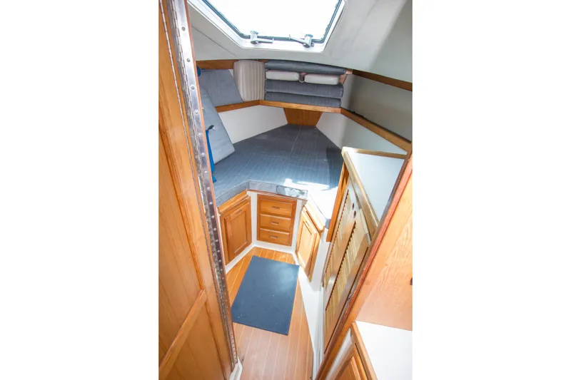 Slide: The Image of Interior cabin of a 1991 Catalina 36 sailboat with wooden cabinetry and cozy sleeping area. - 14