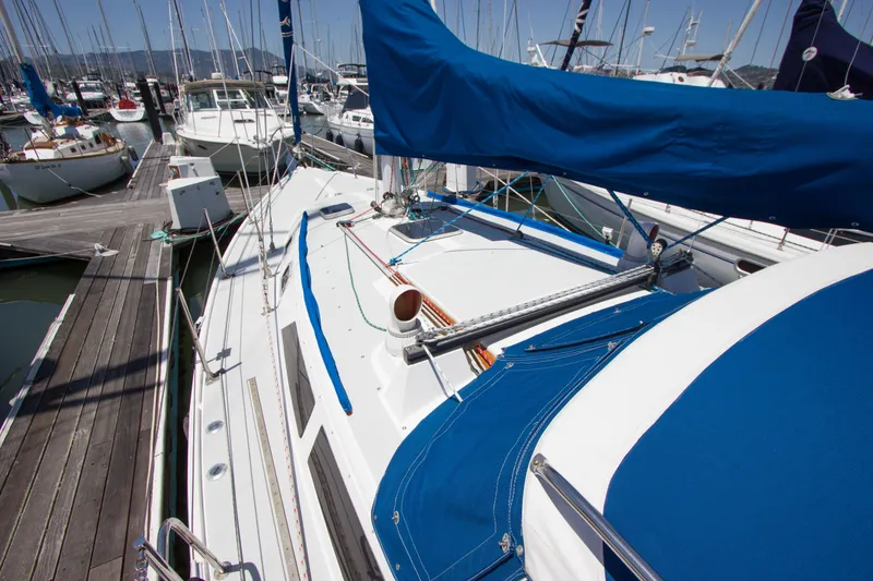Slide: The Image of 1991 Catalina 36 sailboat docked in a marina, featuring blue canvas covers. - 22