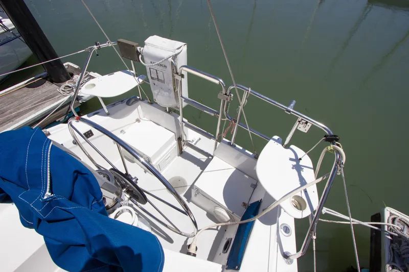 Slide: The Image of Cockpit of a 1991 Catalina 36 sailboat with steering wheel and blue cover. - 25