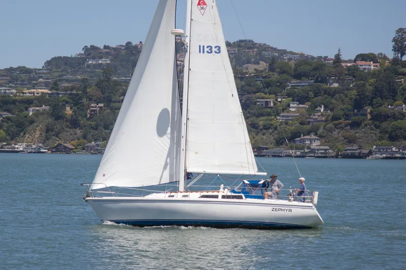 Slide: The Image of 1991 Catalina 36 sailboat "Zephyr" cruising on a scenic lake with hillside homes. - 4