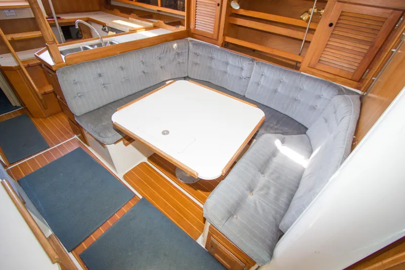 Slide: The Image of Cozy dining area in a 1991 Catalina 36 sailboat with cushioned seating and wooden accents. - 9
