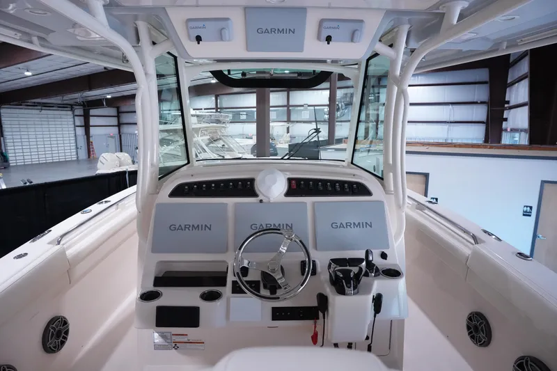 Slide: The Image of 2023 Grady-White Canyon 336 boat dashboard with Garmin navigation systems in a showroom. - 13