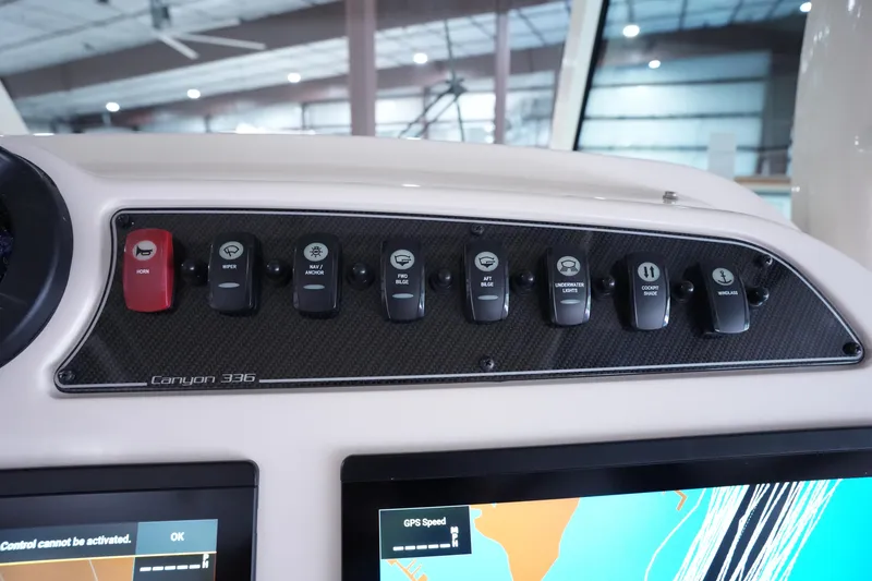 Slide: The Image of 2023 Grady-White Canyon 336 dashboard with control switches and navigation display. - 28