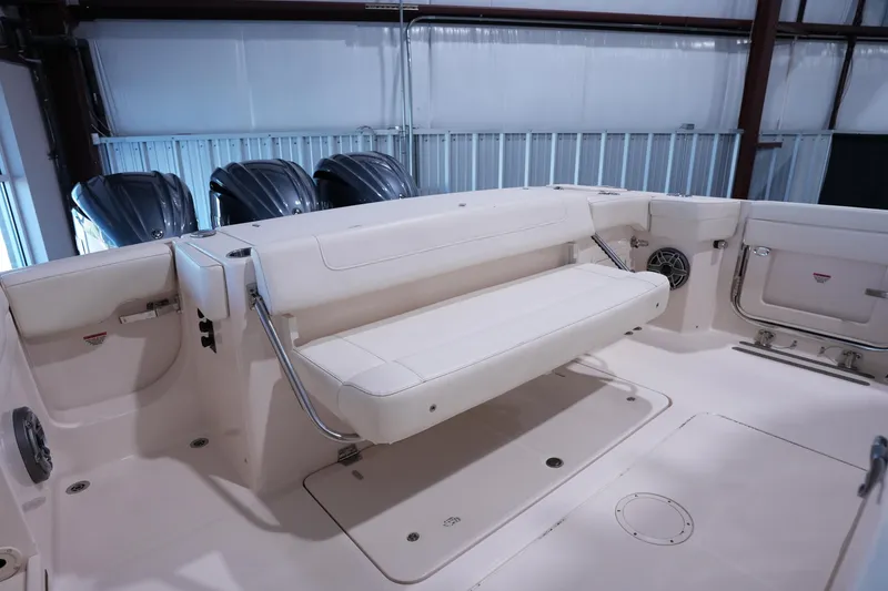 Slide: The Image of 2023 Grady-White Canyon 336 boat interior with foldable seating and triple outboard motors. - 3
