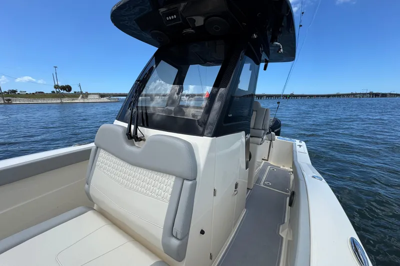 Slide: The Image of 2026 Scout 260 LXF boat on water, showcasing sleek design and comfortable seating. - 13