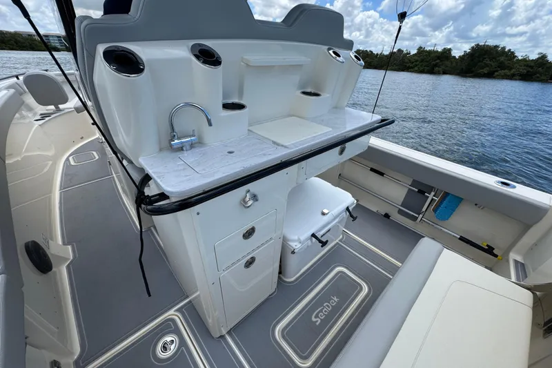 Slide: The Image of 2026 Scout 260 LXF boat interior with sink and storage, overlooking water. - 27