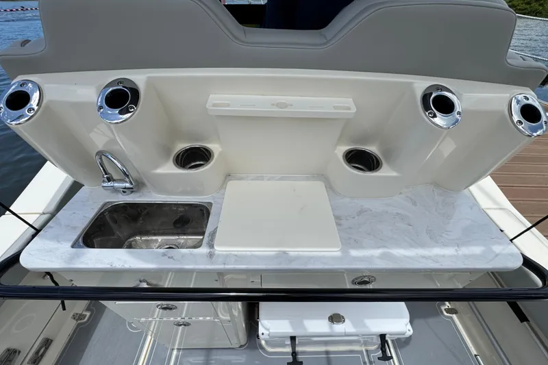 Slide: The Image of 2026 Scout 260 LXF boat interior with sink and rod holders. - 28
