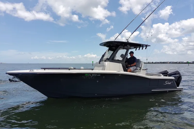 Slide: The Image of 2026 Scout 260 LXF boat on water, featuring sleek design and dual Mercury engines. - 3