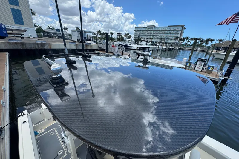 Slide: The Image of 2026 Scout 260 LXF boat with sleek carbon fiber detailing at a marina. - 38