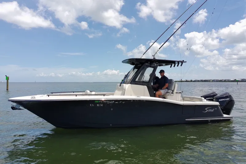 Slide: The Image of 2026 Scout 260 LXF boat on calm water under a partly cloudy sky. - 5