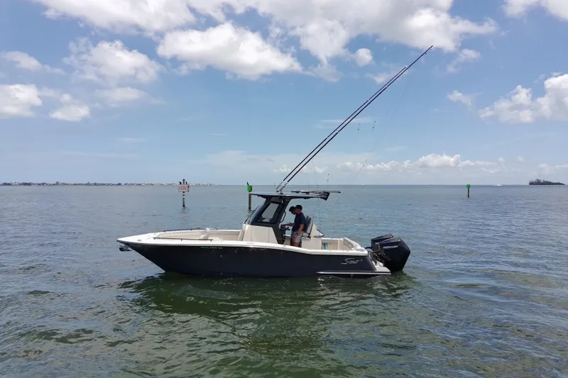 Slide: The Image of 2026 Scout 260 LXF boat on calm water under a partly cloudy sky. - 6