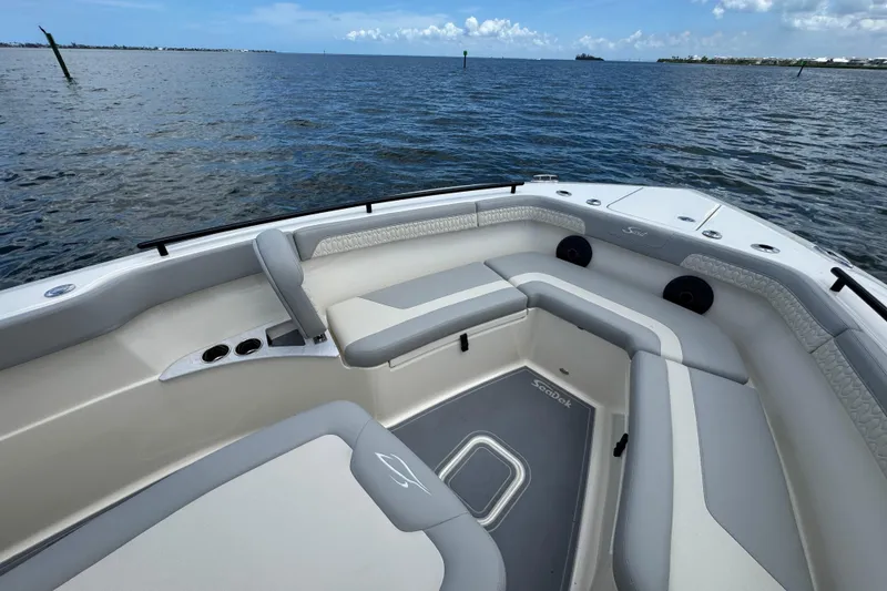 Slide: The Image of 2026 Scout 260 LXF boat interior with cushioned seating, on calm ocean waters. - 9