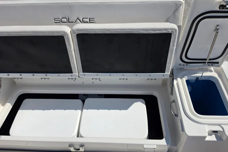 Slide: The Image of 2026 Solace 30CS boat storage compartments with open lids, showcasing interior space. - 24