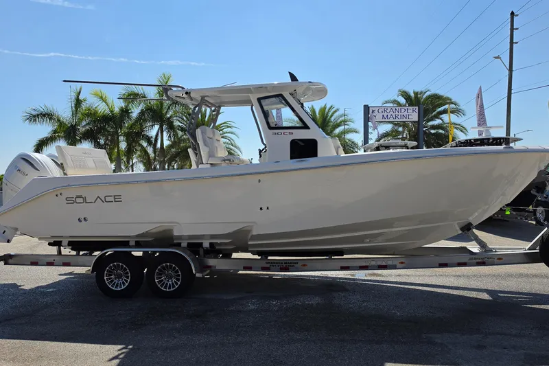 Slide: The Image of 2026 Solace 30CS boat on trailer at Grander Marine dealership, surrounded by palm trees. - 4