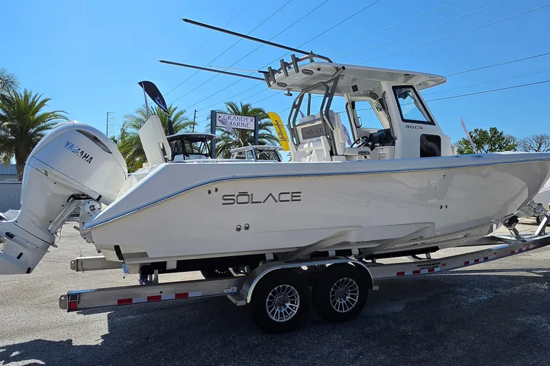 Slide: The Image of 2026 Solace 30CS boat on trailer, featuring Yamaha engine, displayed outdoors. - 7