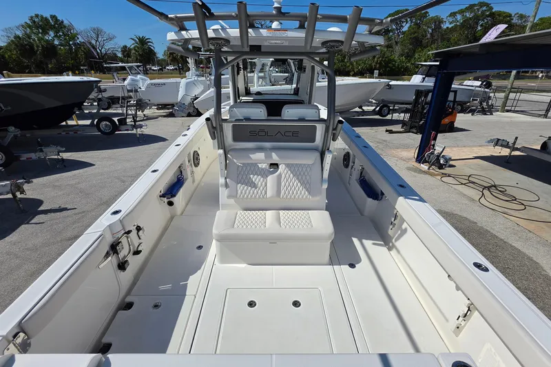 Slide: The Image of 2026 Solace 30CS boat interior with seating and console, displayed outdoors. - 9