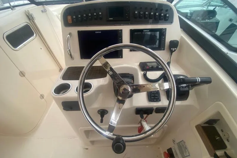 Slide: The Image of 2016 Grady-White Freedom 307 boat helm with steering wheel and control panel. - 7