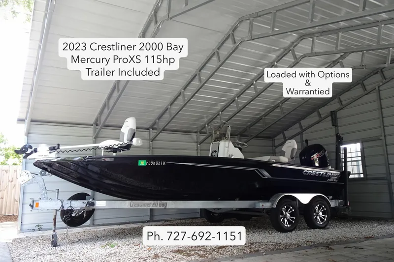 The Image of 2023 Crestliner 2000 Bay boat with Mercury ProXS 115hp engine, trailer included, under shelter. - 0