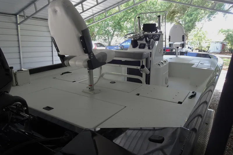 Slide: The Image of 2023 Crestliner 2000 Bay boat interior with seating and control console under a canopy. - 7