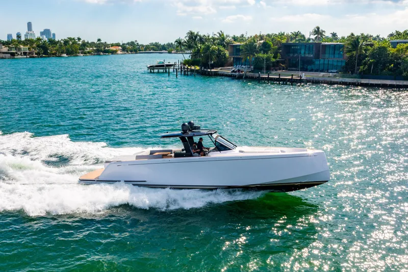 Slide: The Image of 2023 Pardo 50 yacht cruising on a sunny, tropical waterway near luxury waterfront homes. - 12