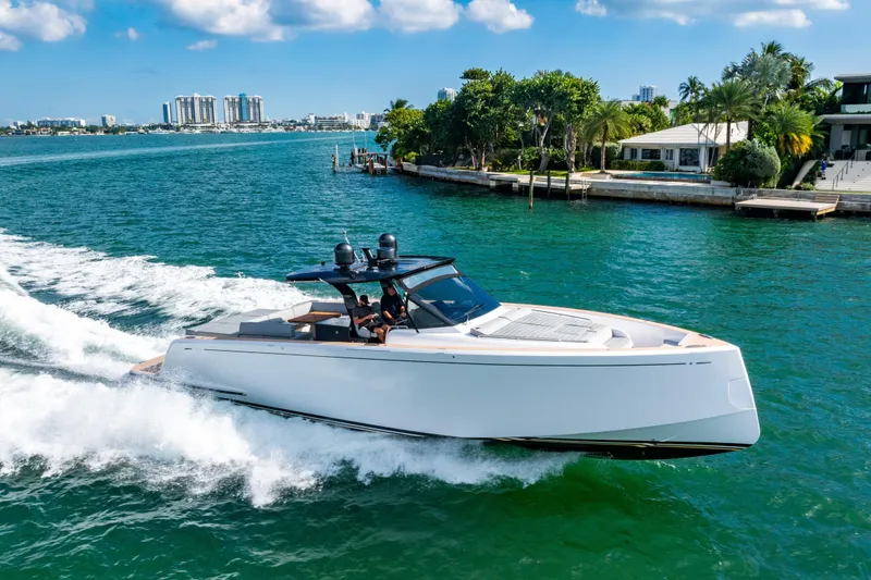 Slide: The Image of 2023 Pardo 50 yacht cruising in sunny coastal waters near luxury homes. - 16