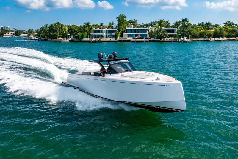 Slide: The Image of 2023 Pardo 50 yacht cruising on clear blue water near luxury waterfront homes. - 27