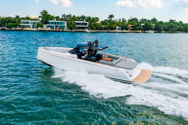 Slide: The Image of 2023 Pardo 50 yacht cruising on a scenic waterfront with modern homes. - 43