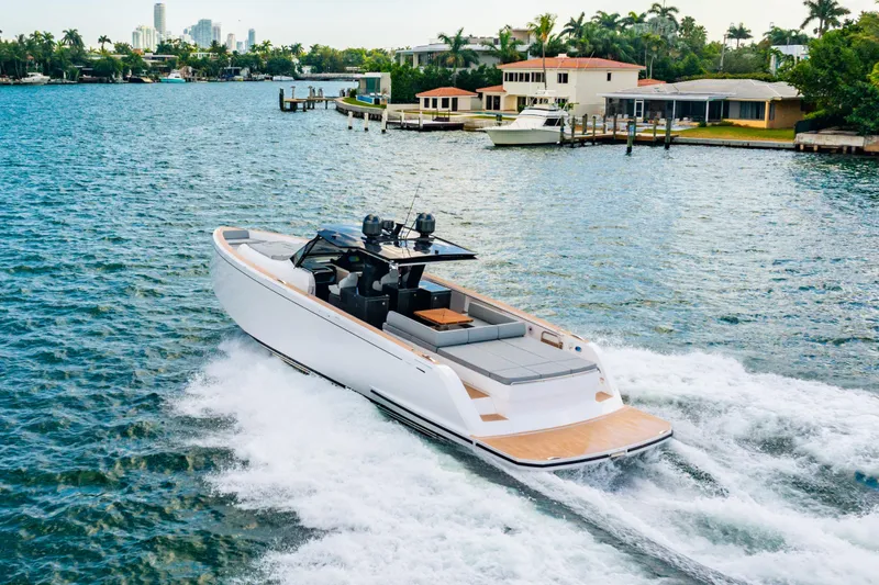 Slide: The Image of 2023 Pardo 50 yacht cruising on a scenic waterfront with modern homes in the background. - 45