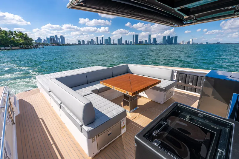Slide: The Image of Luxurious 2023 Pardo 50 yacht with elegant seating, wooden table, and stunning city skyline view. - 55