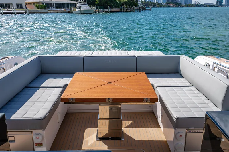 Slide: The Image of Luxurious 2023 Pardo 50 yacht interior with elegant seating and wooden table, overlooking serene waters. - 59