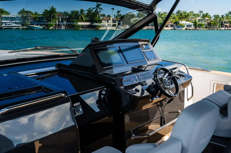 Slide: The Image of Luxury Pardo 50 yacht cockpit with modern controls, overlooking serene waterfront homes. - 71