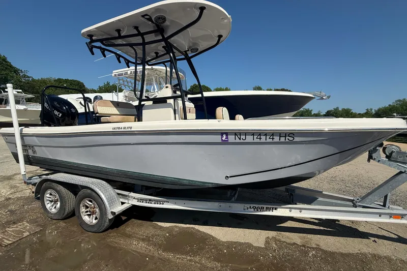 Slide: The Image of 2023 Carolina Skiff 21 Ultra Elite boat on trailer, side view, sunny day. - 2
