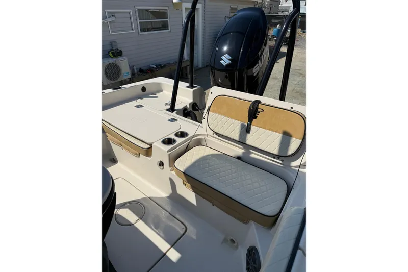 Slide: The Image of 2023 Carolina Skiff 21 Ultra Elite boat interior with cushioned seating and Suzuki outboard motor. - 6