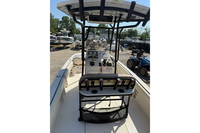 Slide: The Image of 2023 Carolina Skiff 21 Ultra Elite boat interior with console and seating, parked outdoors. - 8