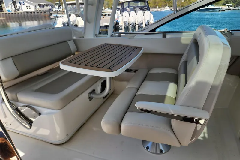 Slide: The Image of Interior of 2021 Boston Whaler 320 Vantage with seating and wooden table. - 13