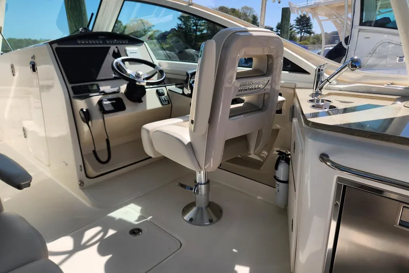 Slide: The Image of Interior of a 2021 Boston Whaler 320 Vantage boat, featuring helm and seating area. - 14
