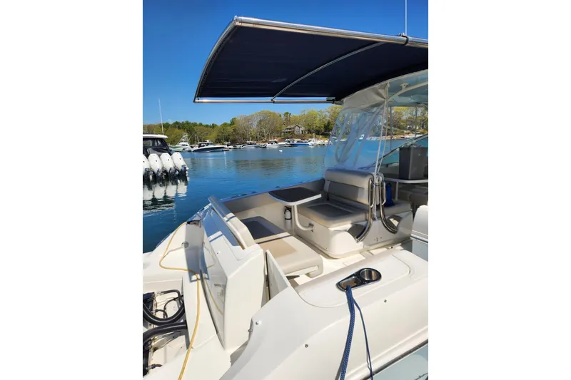Slide: The Image of 2021 Boston Whaler 320 Vantage boat interior with seating and canopy on a sunny day. - 17
