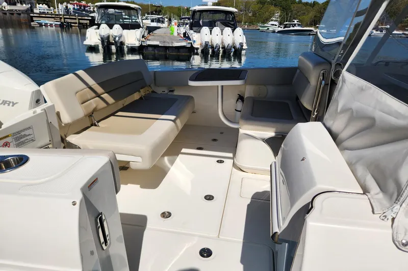 Slide: The Image of 2021 Boston Whaler 320 Vantage interior with seating, docked in a marina. - 18