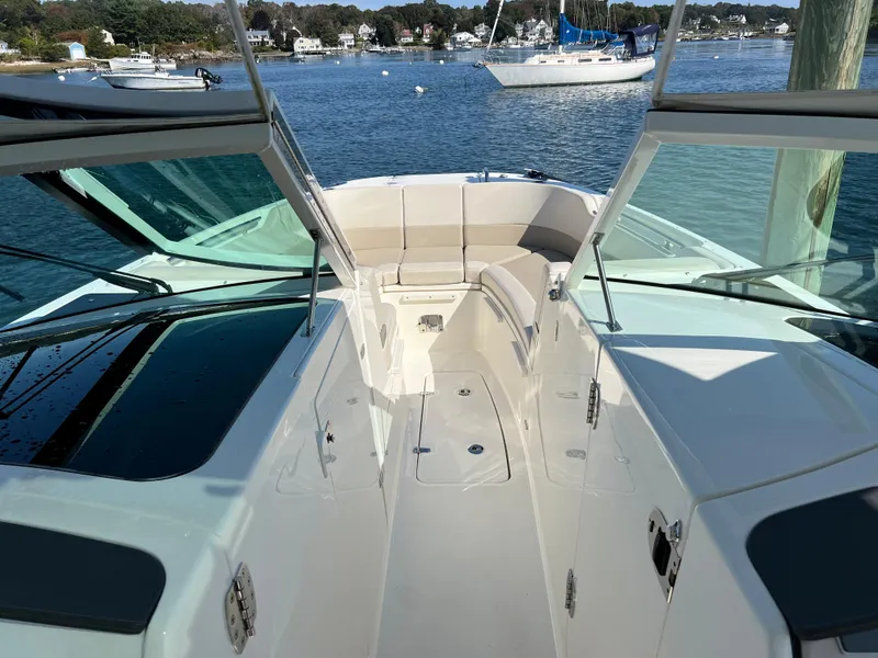 Slide: The Image of Boston Whaler 320 Vantage 2021 on calm water with sailboat in background. - 9