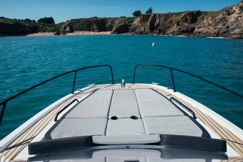 Slide: The Image of 2024 Beneteau Flyer 8 SUNdeck boat cruising near rocky coastline. - 13
